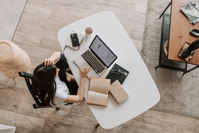 Jovem usando um laptop em uma mesa em um espaço de trabalho moderno.