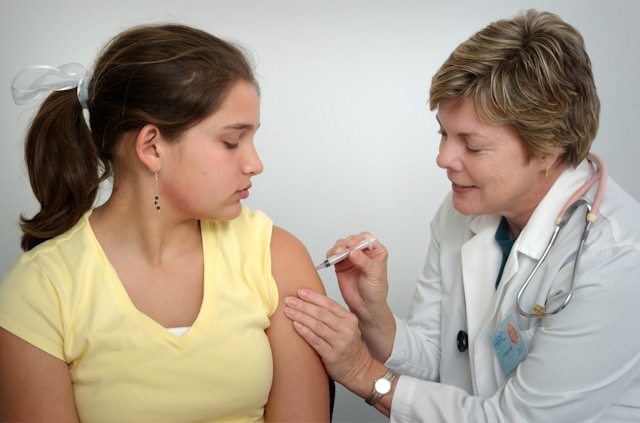 Uma pessoa recebe uma injeção de um médico.