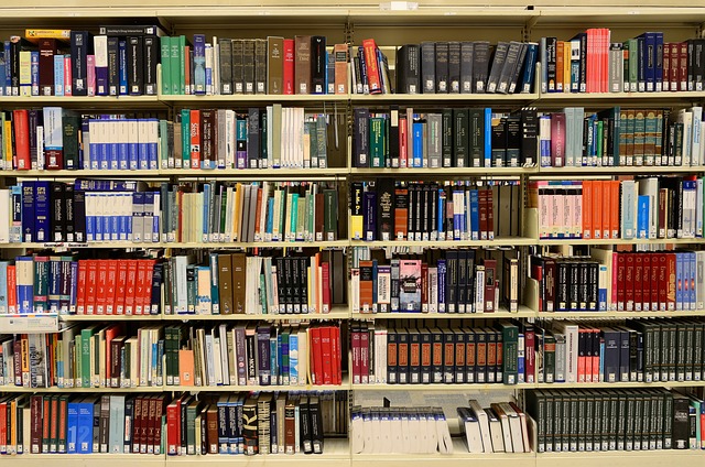 A estante de uma biblioteca contém muitos livros.
