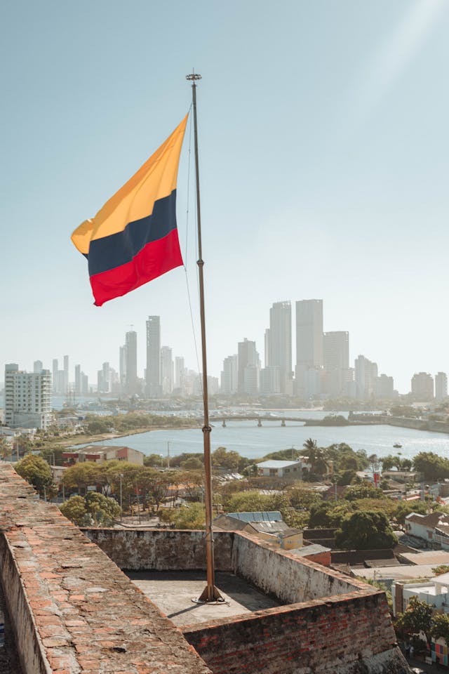 Qual é o país mais fácil para adotar? 6 A bandeira colombiana com a linha do horizonte de Cartagena ao fundo.