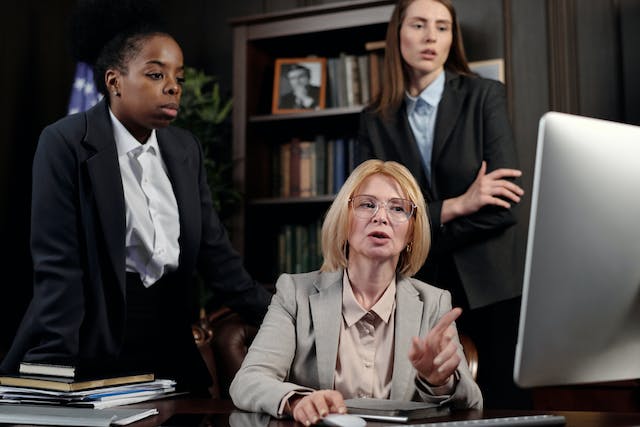 Weibliche Anwälte in einem Büro, die auf einen Computer schauen.
