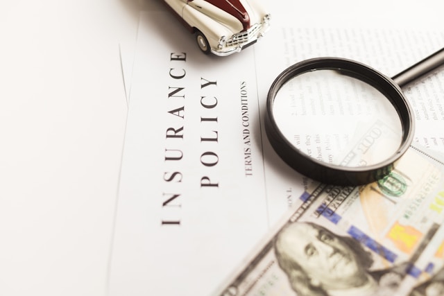 Servicios de traducción de seguros: Por qué son importantes 3 Una póliza de seguros con una lupa, un coche de juguete y un billete de 100 dólares.