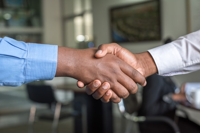 Agence de traduction professionnelle : Trouver la meilleure en ligne 3 Deux personnes se serrent la main pour conclure un accord.