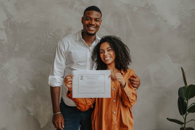 Adoption nationale ou internationale : Comment cela fonctionne-t-il 6 Un couple tient un certificat d'adoption.