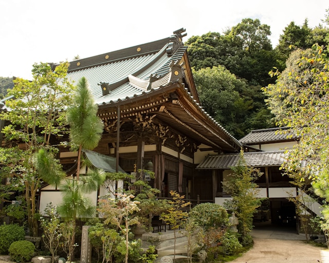 Gros plan sur une grande maison japonaise entourée d'arbres.