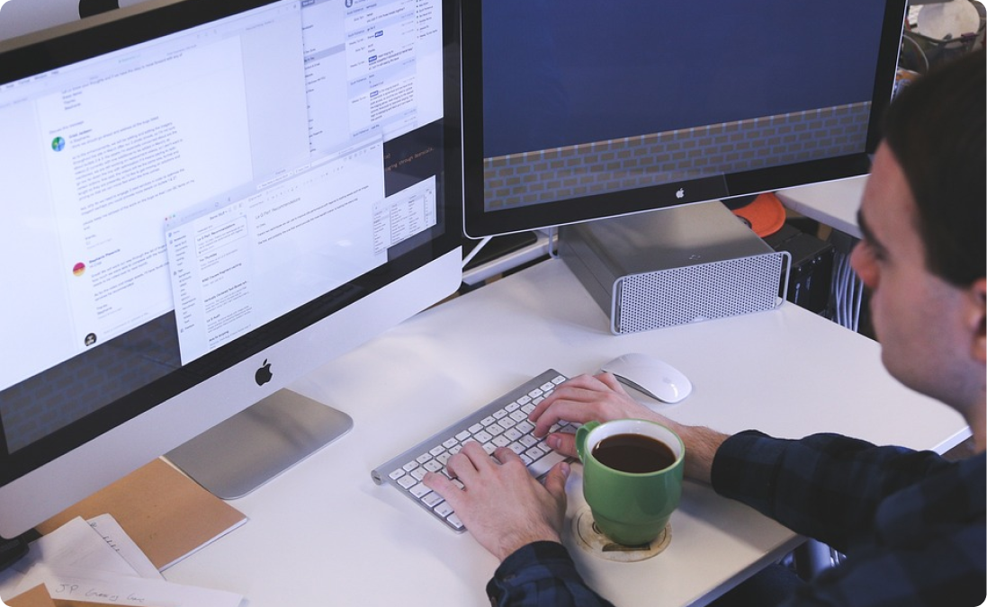 Someone working on a Spanish translation project at their computer with a cup of coffee.