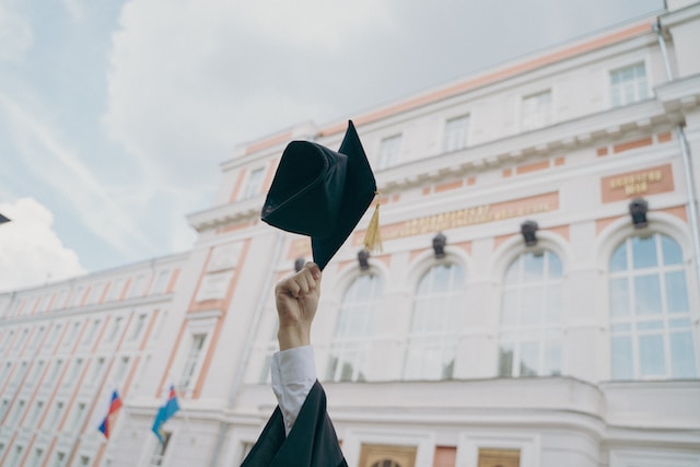 Un laureato che lancia il suo cappello in aria.