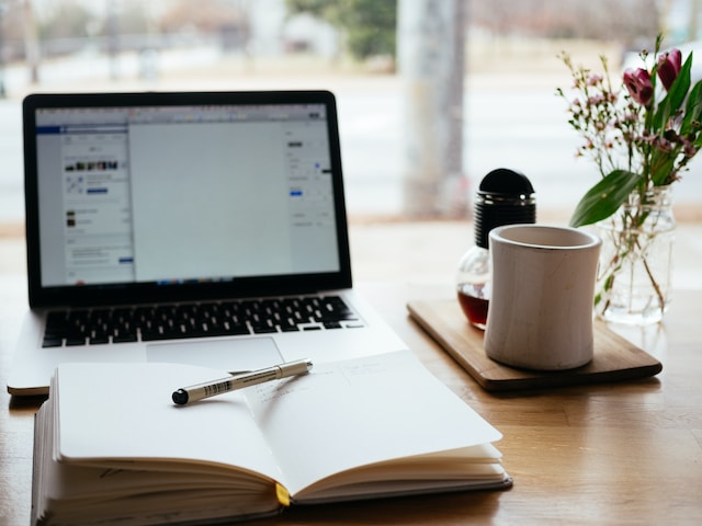 A laptop and notepad prepared for someone to study language translations. 