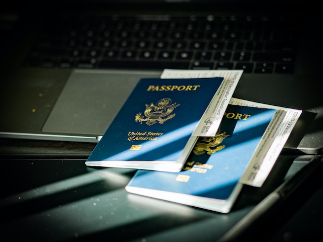 Two passports sitting against a computer.