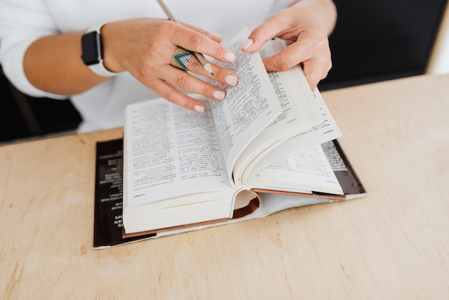 A woman reading a dictionary.