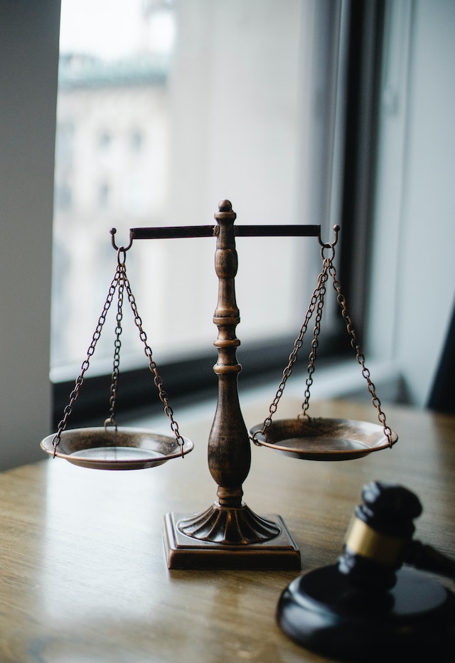 A judgement scale and gavelon a desk in a judge's office.