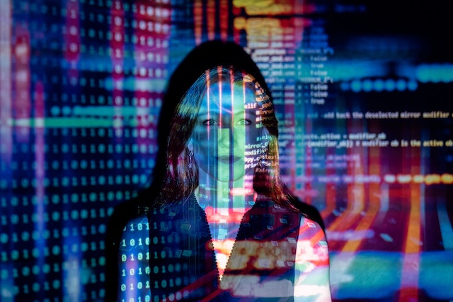 Computer code projected over a woman's face.