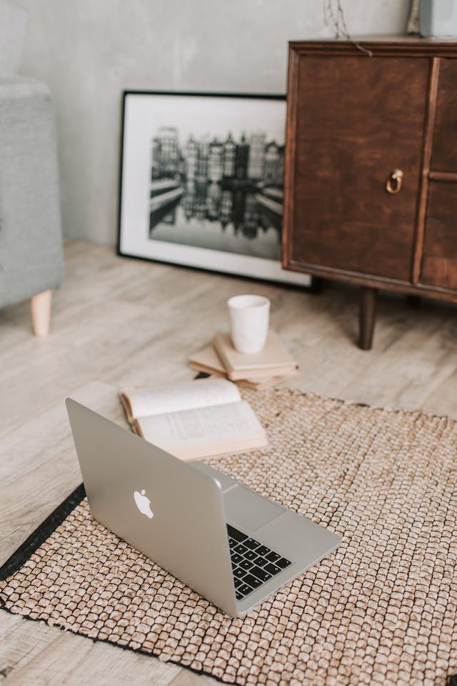  Laptop and books on the floor carpet.