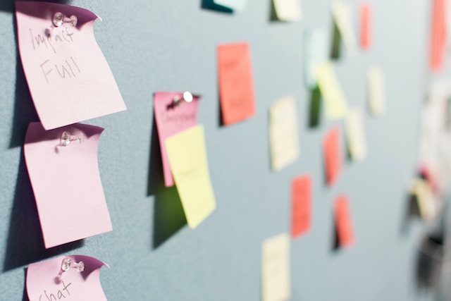 A picture of several notepads attached to a blue wall.