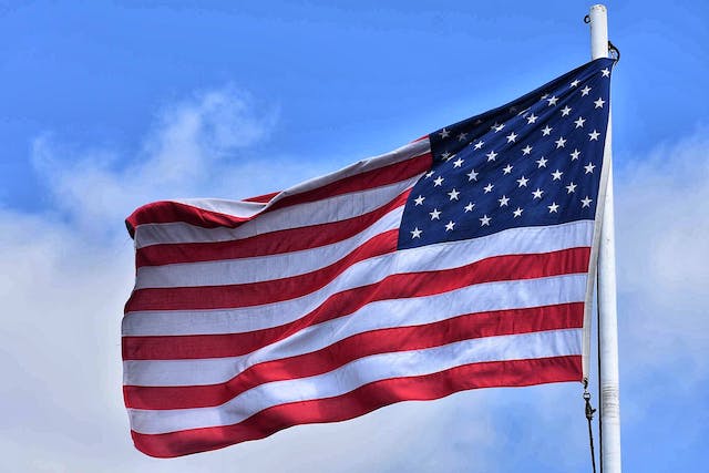 Flag of the U.S. waving on a pole.
