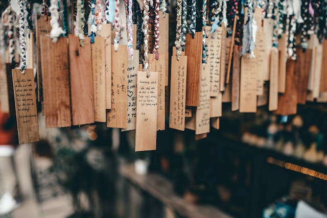 A photograph of several tags hanging on colorful threads.