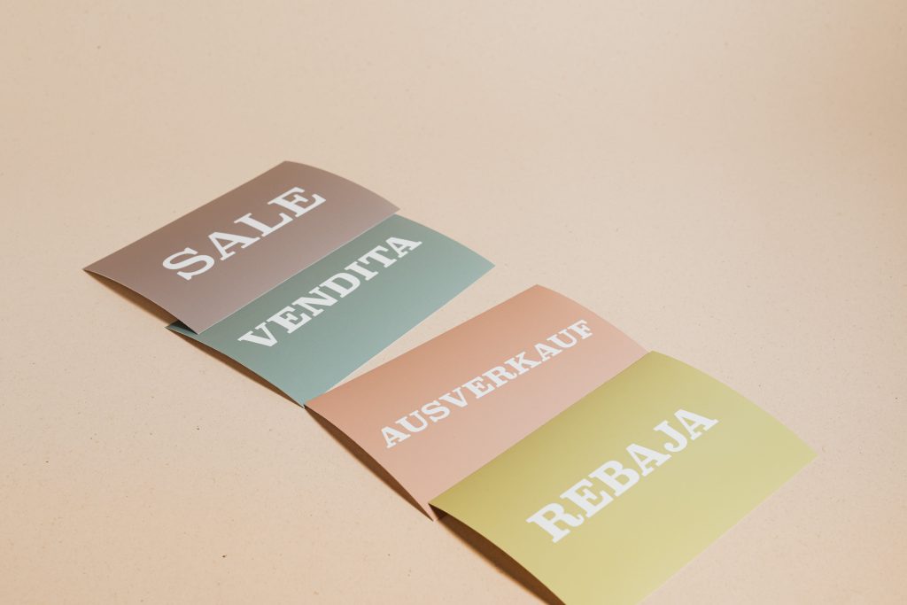 A picture of four cards with the word “SALE” in different languages.
