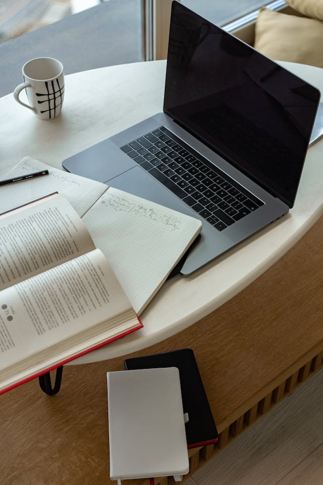 A laptop and notebook with translation notes. 