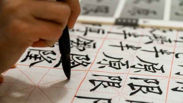 A picture of a person writing in Chinese on paper.
