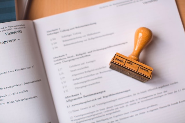 A picture of a brown wooden stamp on an open page in a booklet.