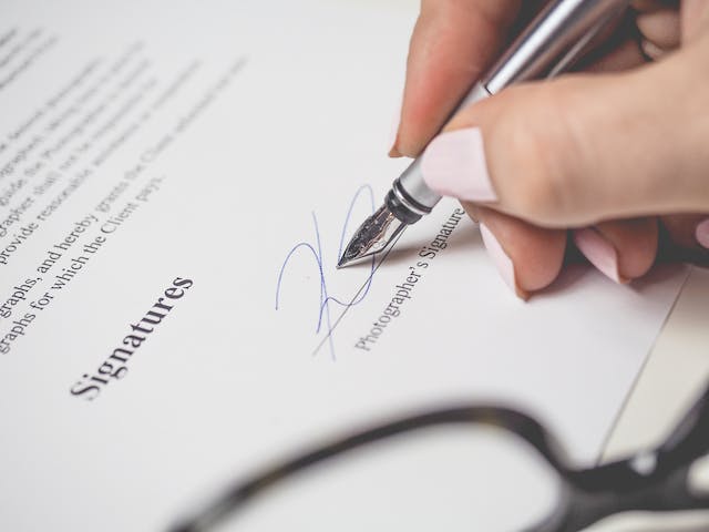 A picture of someone entering their signature on a document.