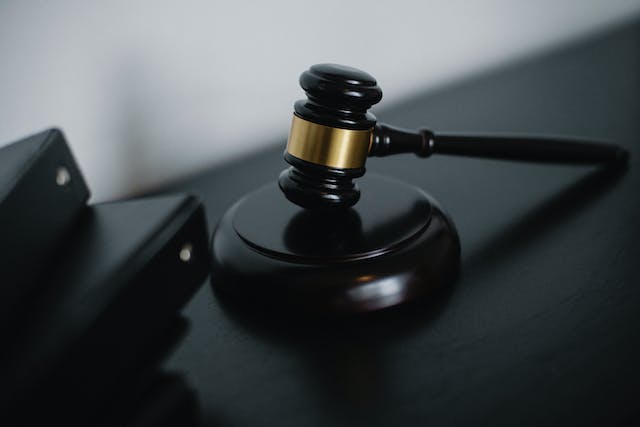 A closeup picture of a wooden gavel on a table.