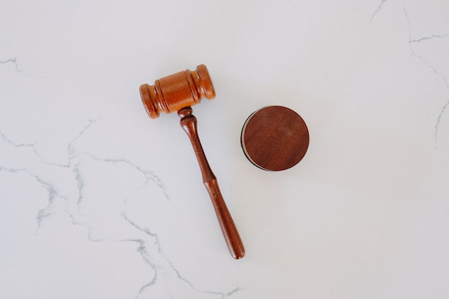  A brown, wooden gavel on a white marble surface.