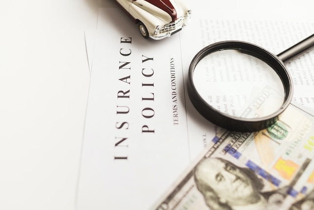 A picture of a magnifying glass and a dollar bill on an insurance policy.
