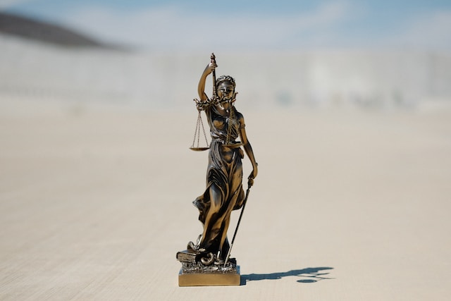 A bronze statue of Lady Justice holding a scale and a sword. 