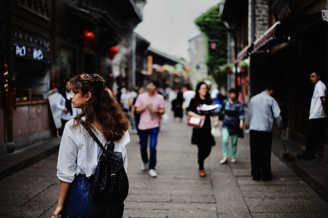 A picture of people walking on a street in an urban setting.