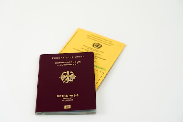 A picture of a red passport with a yellow certificate in it.
