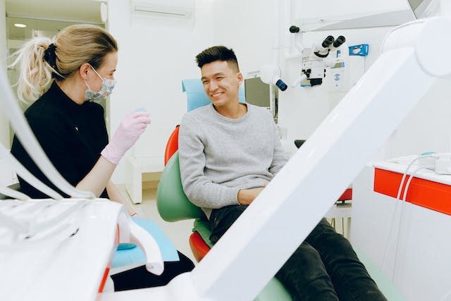 A picture of a medical staff talking to a patient in a facility.