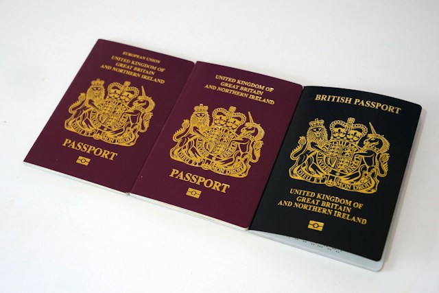 Three British passports side-by-side on a table.