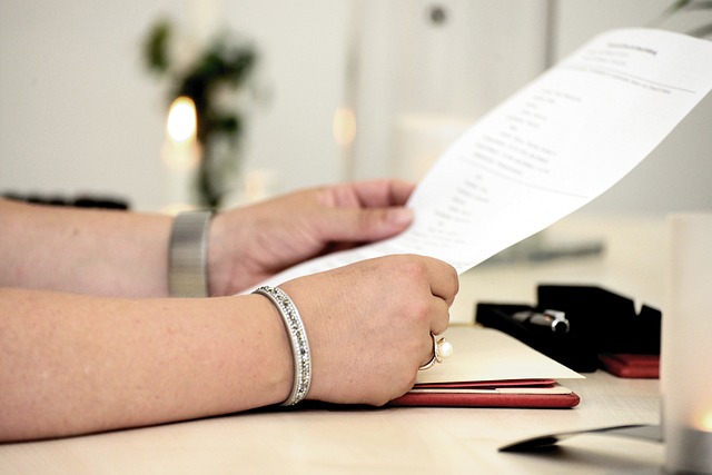 A person holds a printed document.
