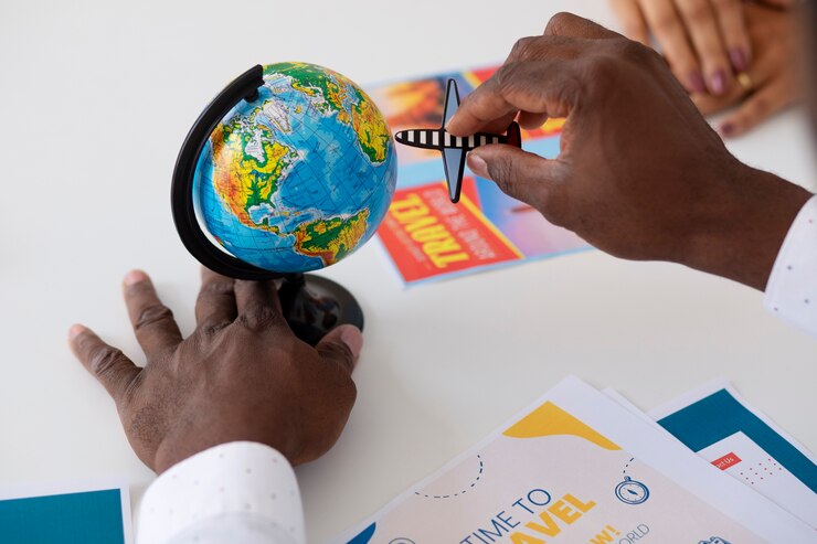 A person places a small airplane figurine on a mini globe.