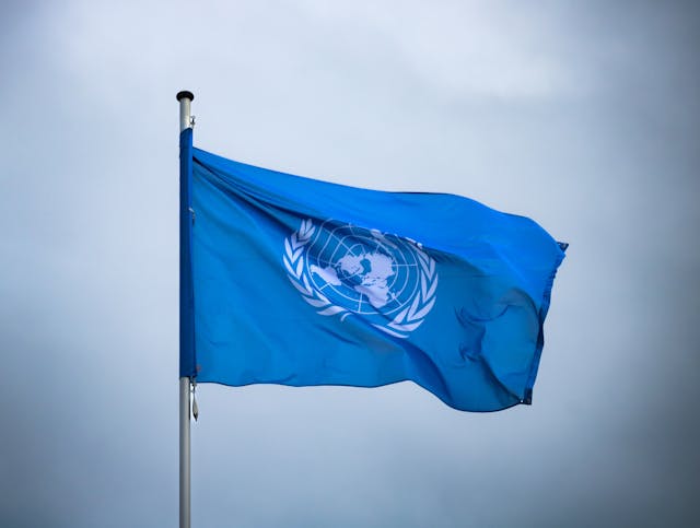 A United Nations flag flying in the wind.
