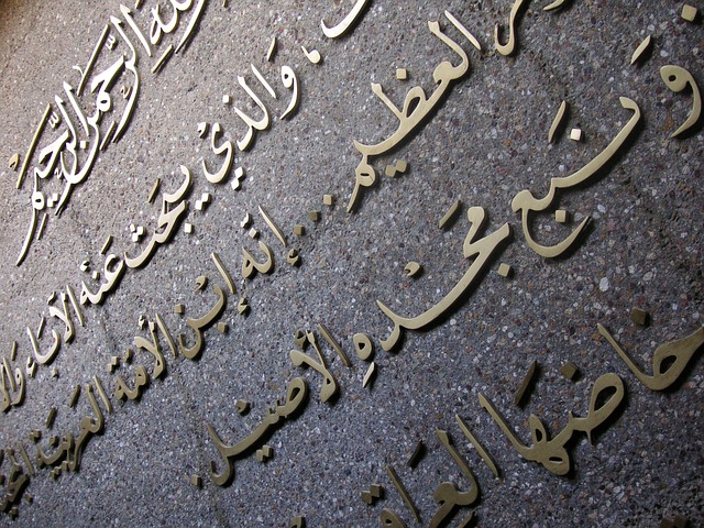 Close-up view of Arabic text on a concrete surface.