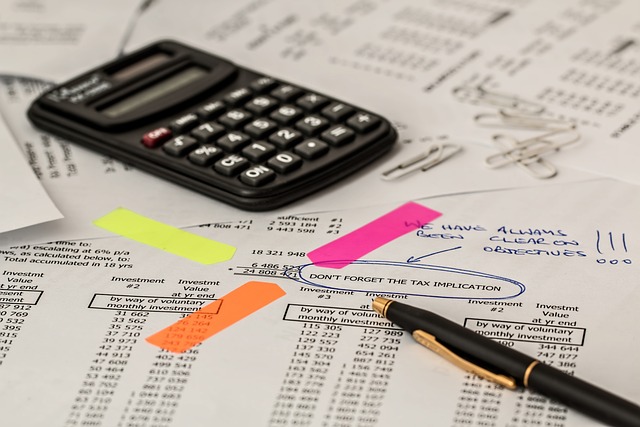 A calculator and pen on a printed accounting document.
