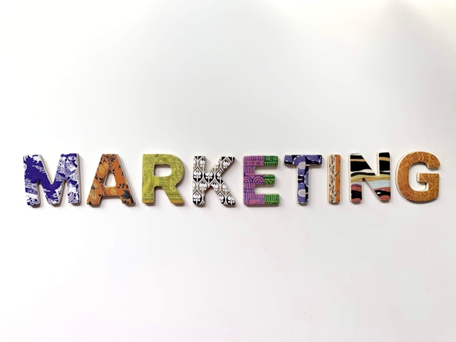 Multicolored freestanding letters spell “MARKETING” on a white background.
