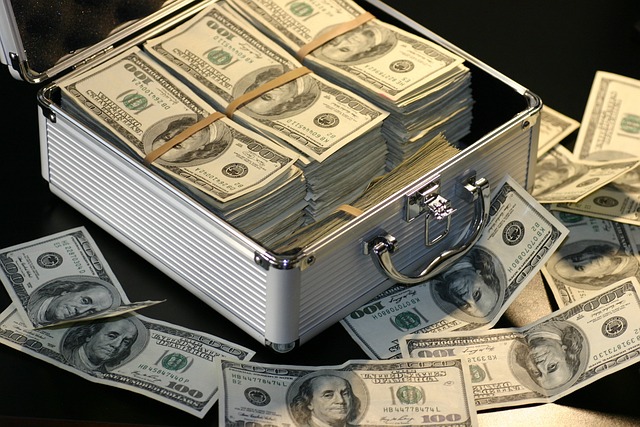 Dollar bundles and notes in and around a briefcase.
