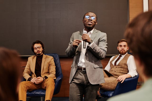 A person addresses people in a conference room.
