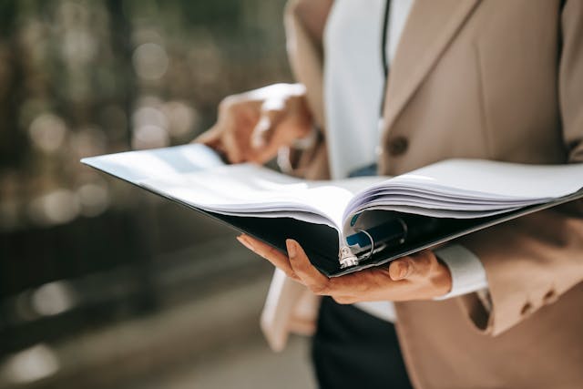  A person holds a document in a folder.