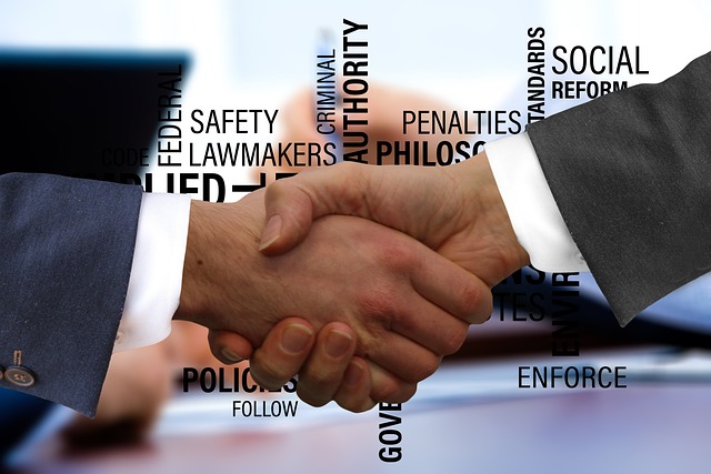 A handshake between two people and various terms for government agencies floating in the background.
