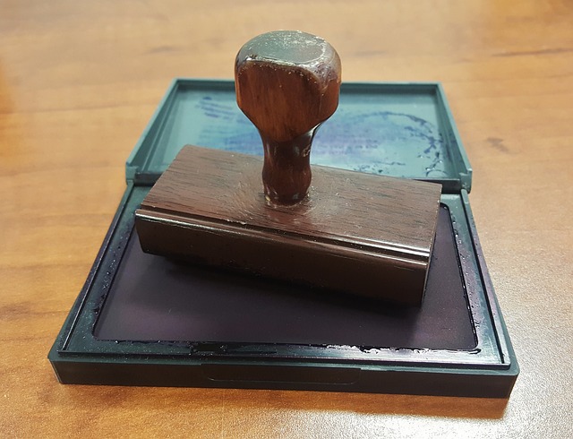 A rubber stamp on a wooden desk.
