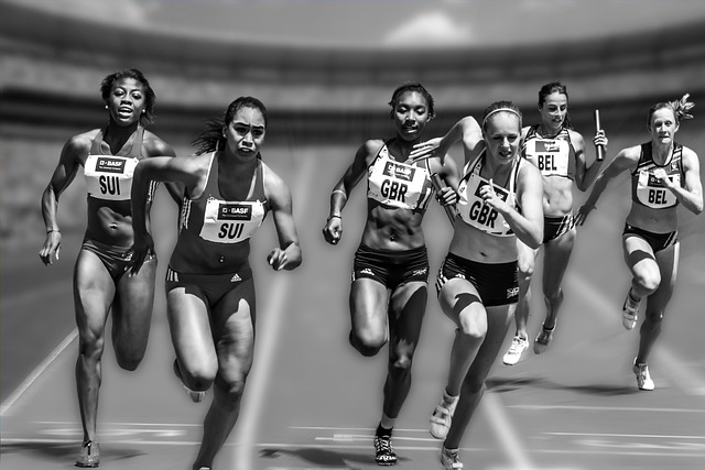 A group of athletes run on a race track.
