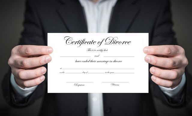 Two hands hold up a certificate of divorce.
