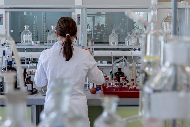 Back view of a scientist surrounded by lab equipment in a laboratory.
