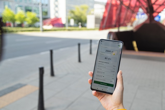 A hand holds a phone displaying a screen on a Fintech application.
