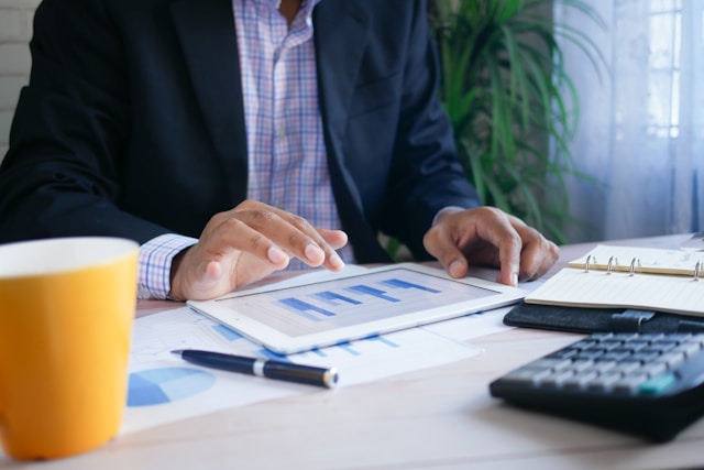 Financial Translation: Where To Get This Service 3 A person uses a tab on a desk displaying graphs on its screen.
