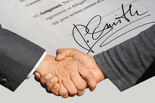 What Is a Certificate of Translation Accuracy? 6 Two people shake hands over a document with a signature.